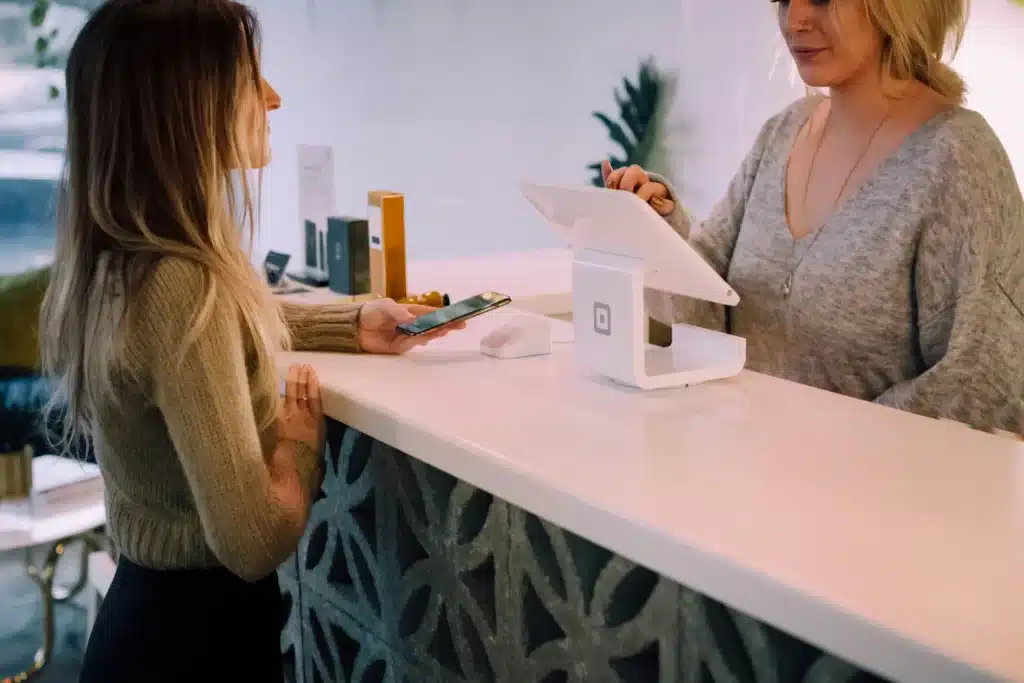 mulher pedindo comida para garçonete utilizando sistema de gestão para restaurante